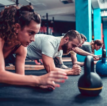 Athletes Practicing Plank Exercise With Kettlebells athletes practicing plank exercise with kettlebells