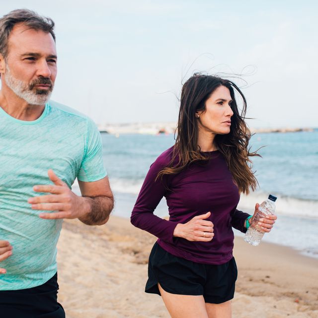 athletic couple jogging on the beach