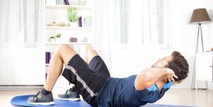 Athletic Man Doing Curl Ups Exercise at Home