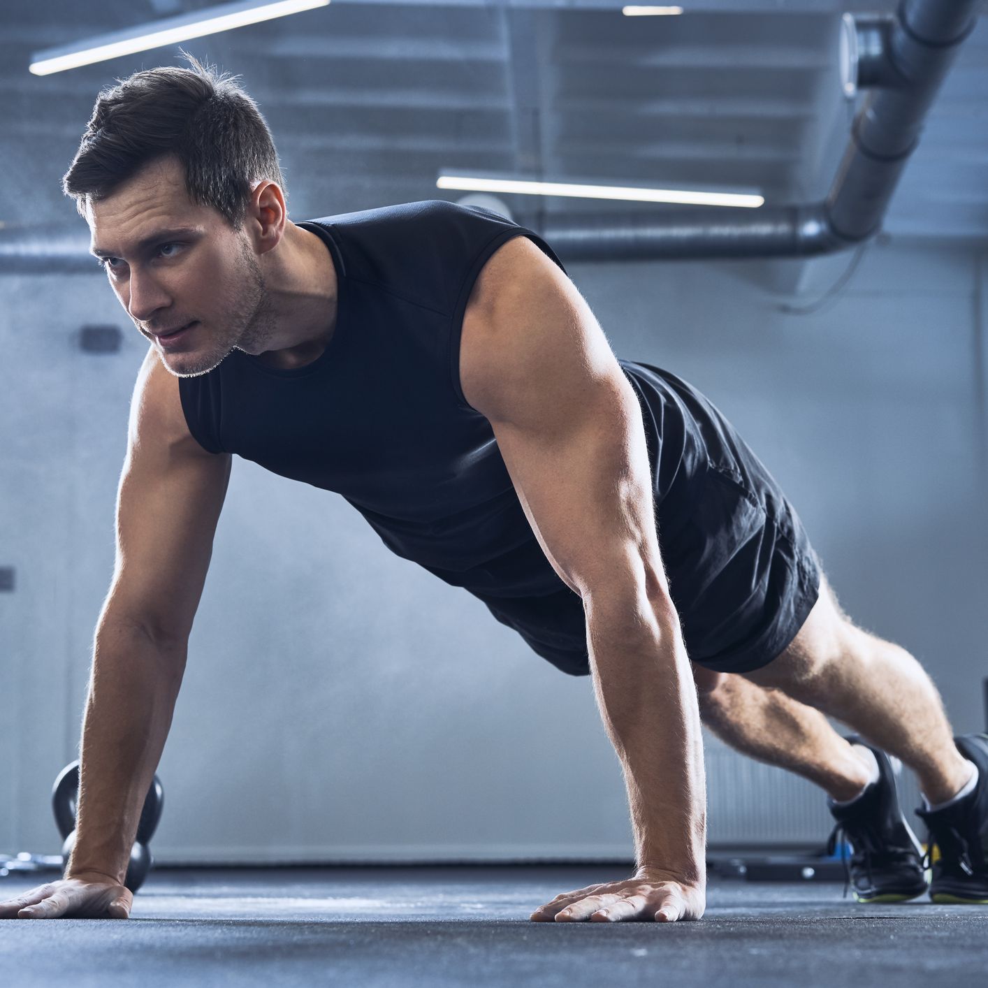 https://hips.hearstapps.com/hmg-prod/images/athletic-man-doing-pushups-exercise-at-gym-royalty-free-image-1587391897.jpg?crop=0.66714xw:1xh;center,top&resize=2048:*