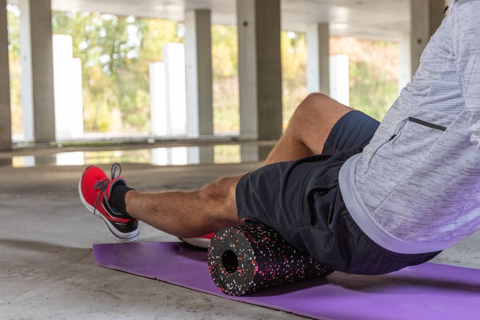 Athletic Man in Side Planking Using Foam Roller