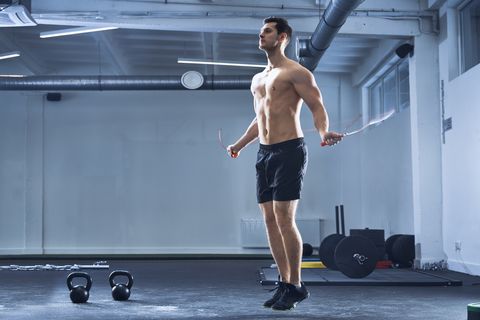 Athletic man skipping rope at gym