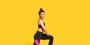 athletic slim young woman with hair bun in tight sportswear doing sport lunge exercise, standing one knee