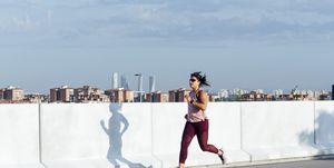 athletic woman running in the street, running base, base training running plan