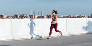 athletic woman running in the street, running base, base training running plan