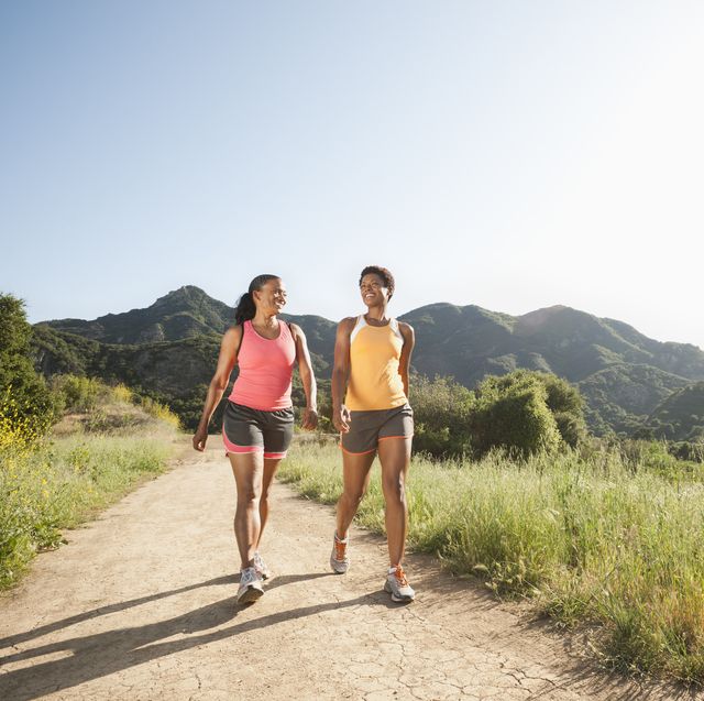 Athletic women walking together on remote trail