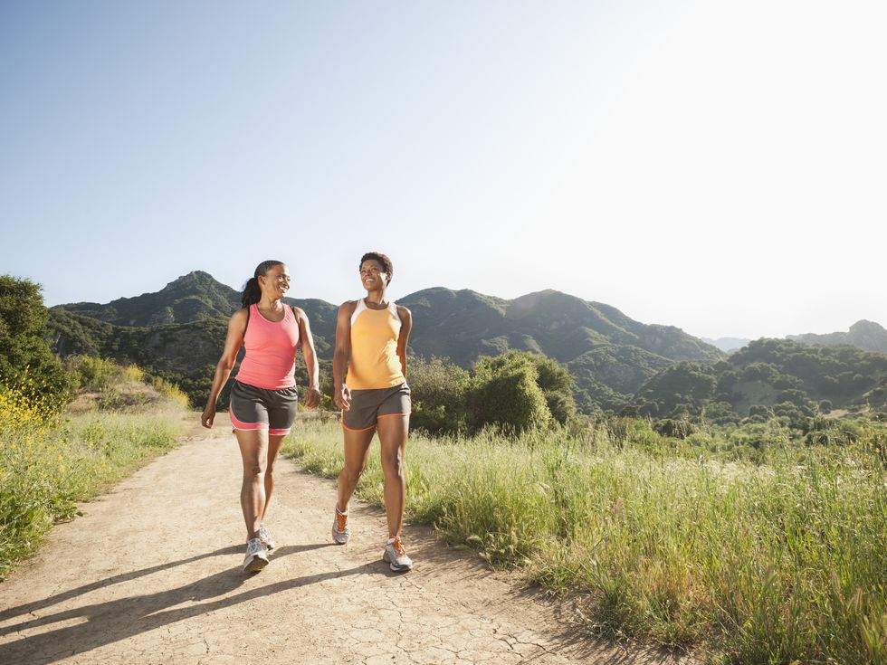 athletic women walking together on remote trail