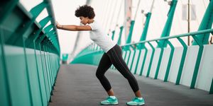 athletic, young woman exercising on city bridge