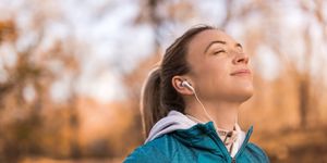 athletic young woman meditating outdoors on beautiful autumn morning
