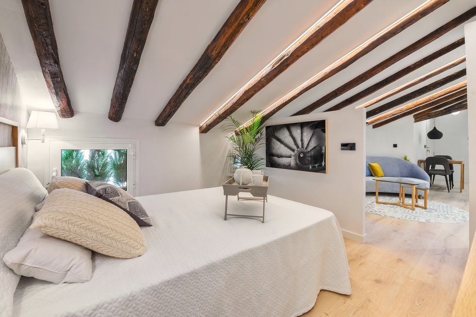 dormitorio abuhardillado con vigas de madera