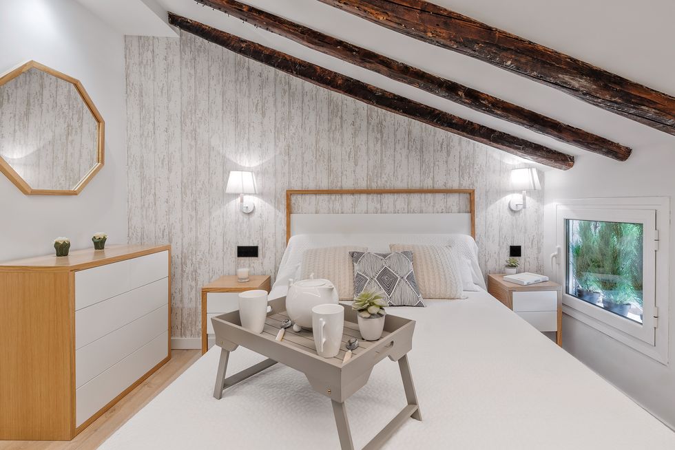 dormitorio abuhardillado con vigas de madera