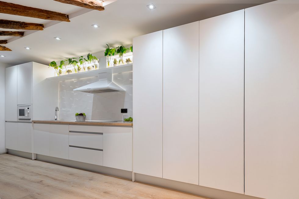cocina blanca abierta moderna con techo abuhardillado