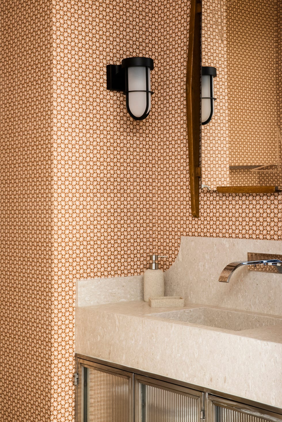 baño con papel pintado geométrico y encimera de mármol