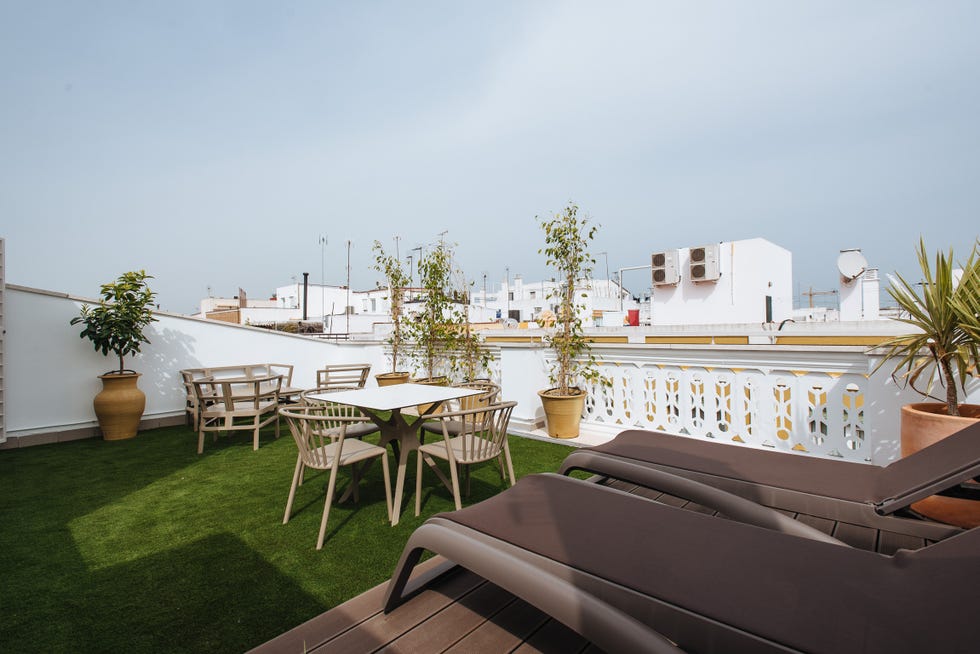 terraza con césped artificial y zonas de asientos