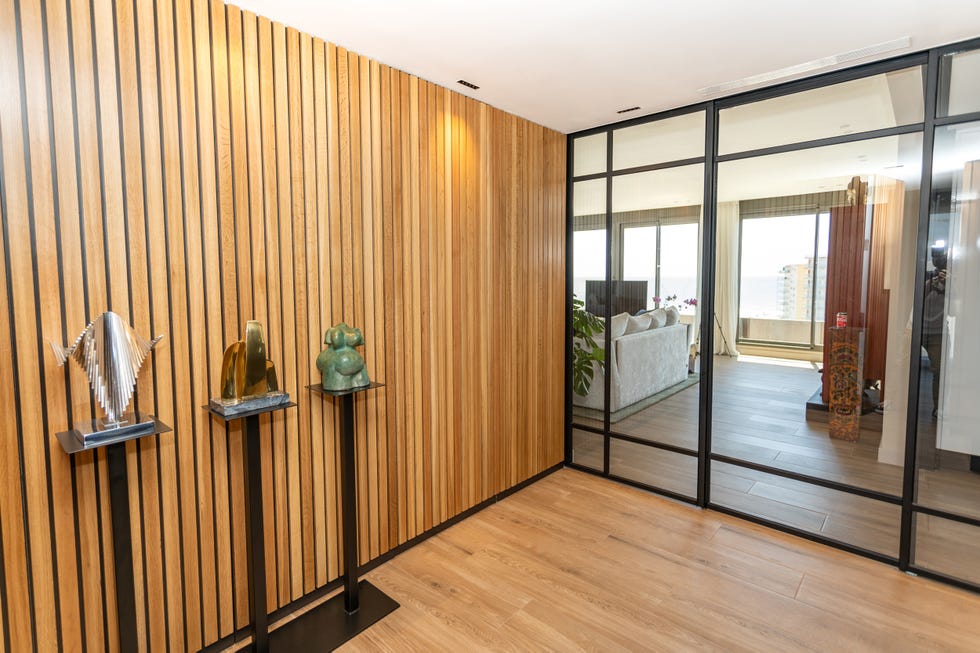 hall con lamas de madera y cerramiento de vidrio