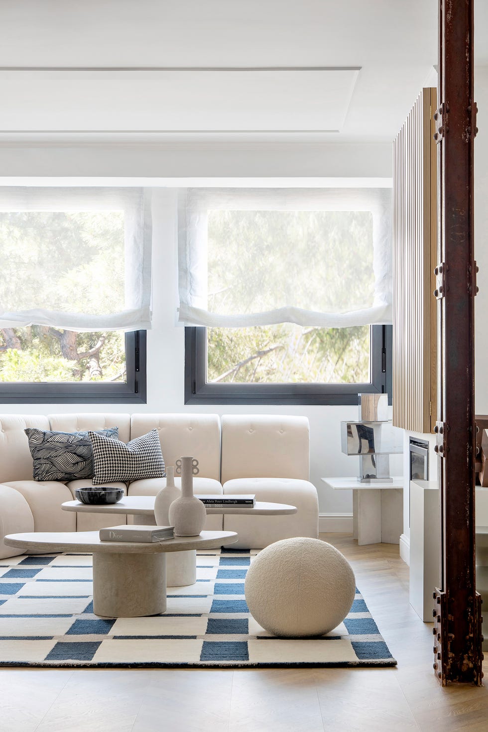 salón con sofá rinconera y puf de rizo blanco