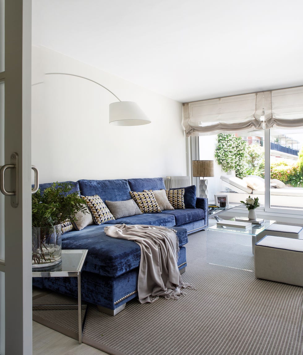salón con sofá de terciopelo azul con chaise longue