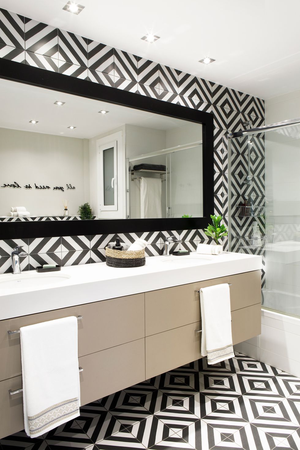 baño moderno con mueble suspendido y azulejos geométricos en blanco y negro