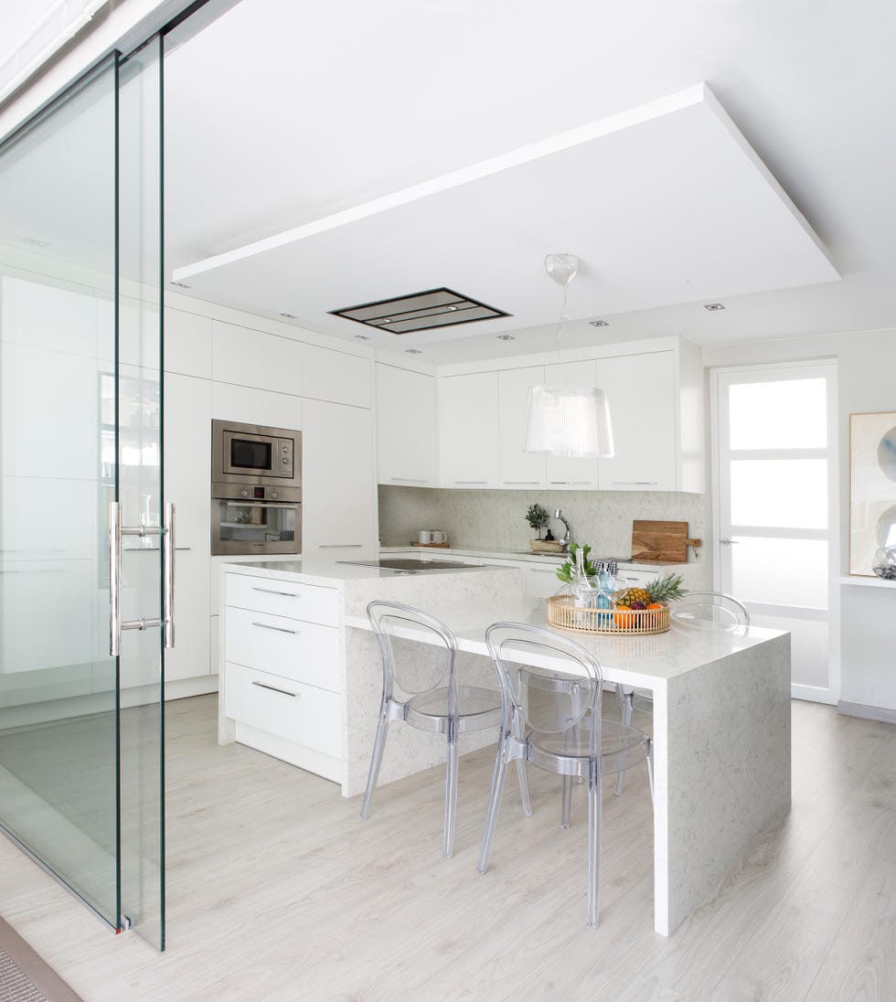 cocina blanca con isla central de mármol