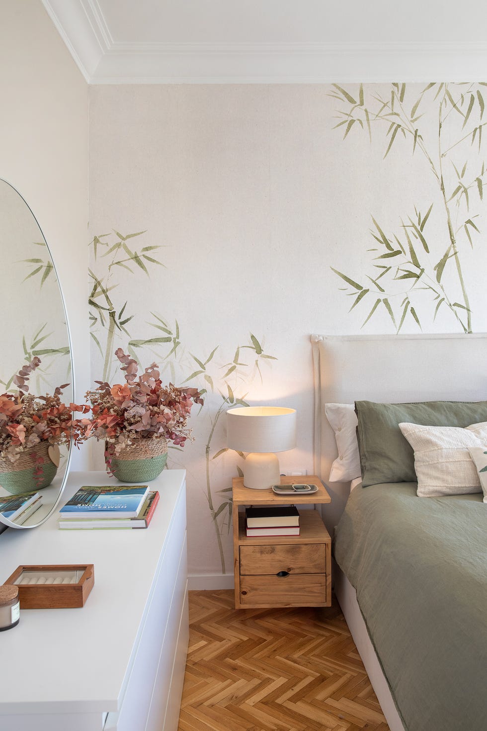 dormitorio con papel pintado con motivos botánicos y mesita de noche de madera