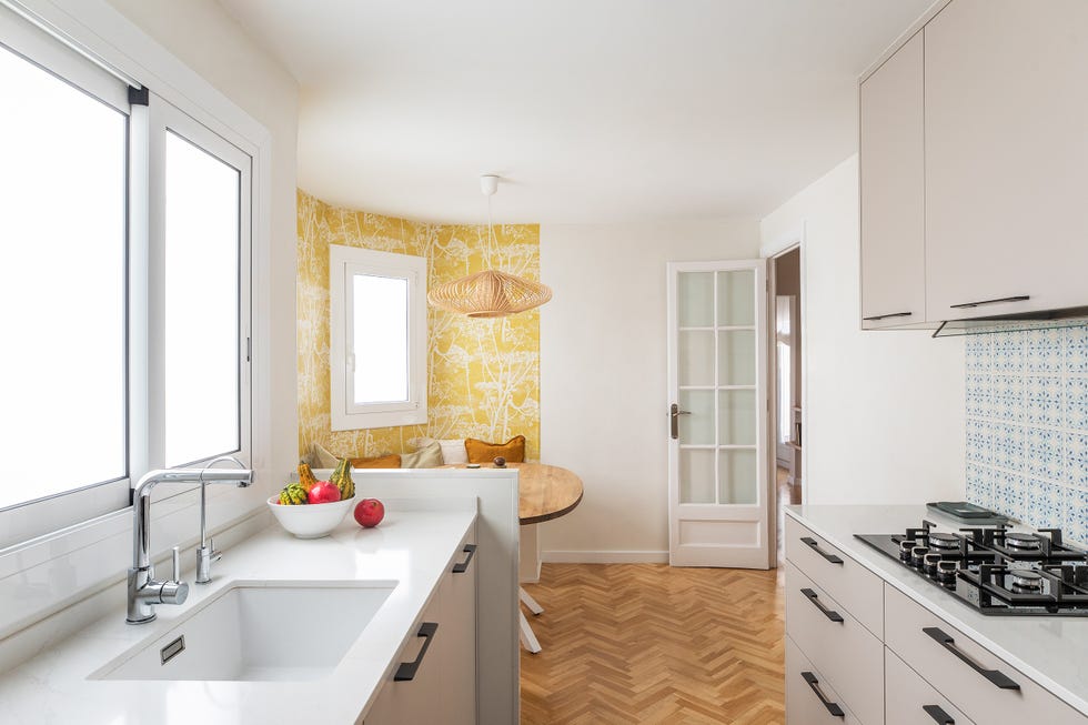 cocina con armarios grises y office con papel pintado en tonos amarillos