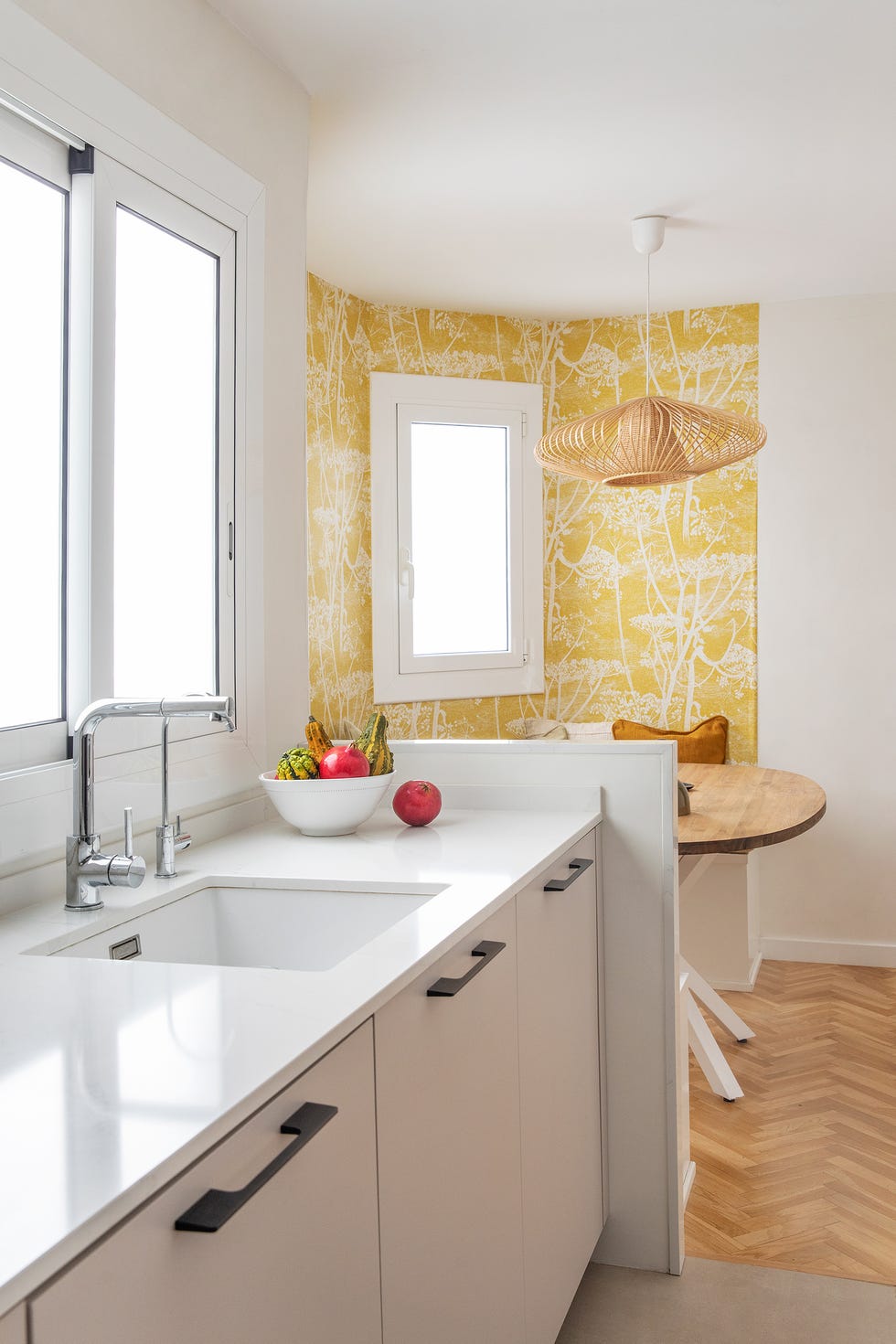 cocina con armarios grises y office con papel pintado en tonos amarillos