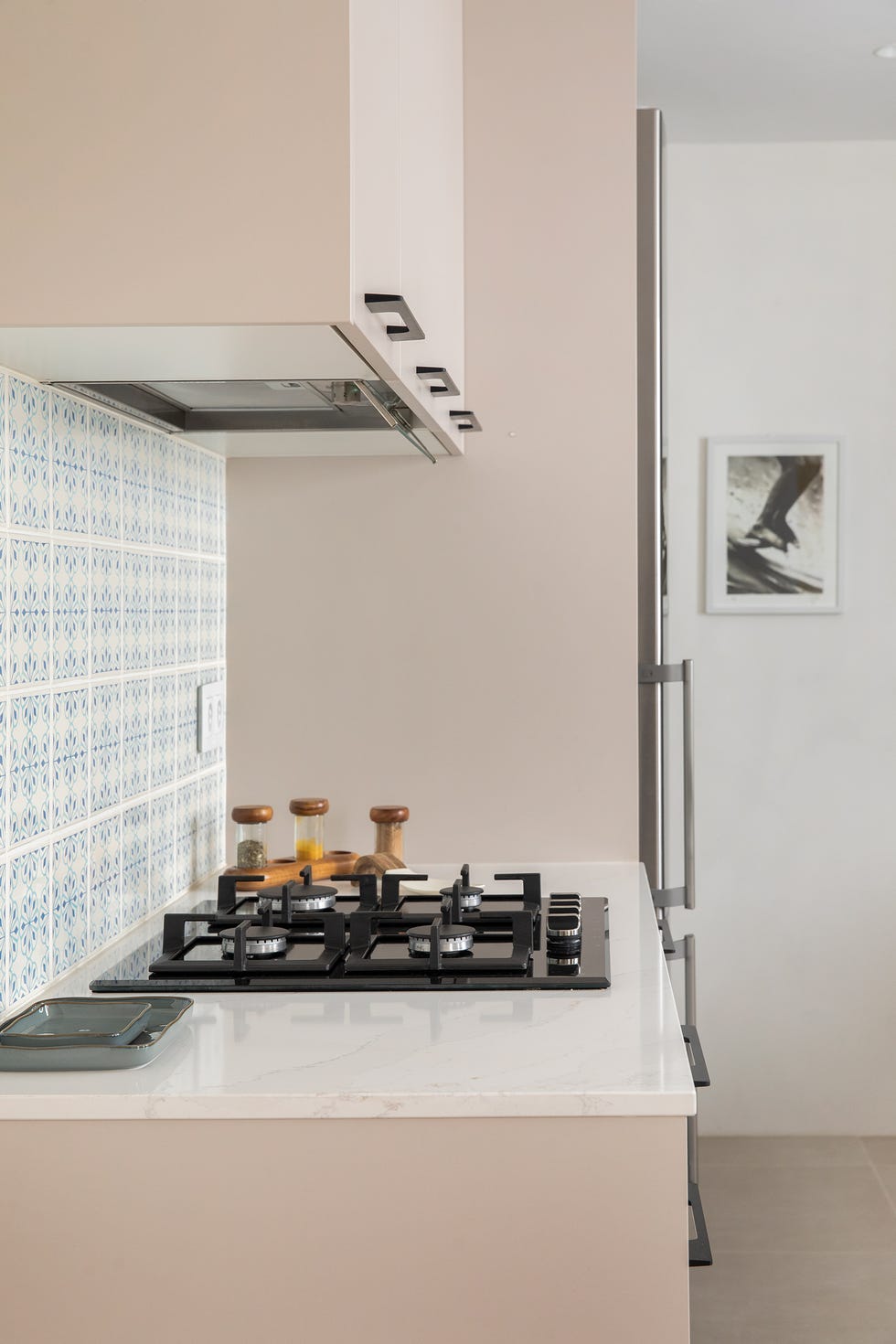 cocina con encimera de mármol, armarios grises y frente de azulejos en mosaico