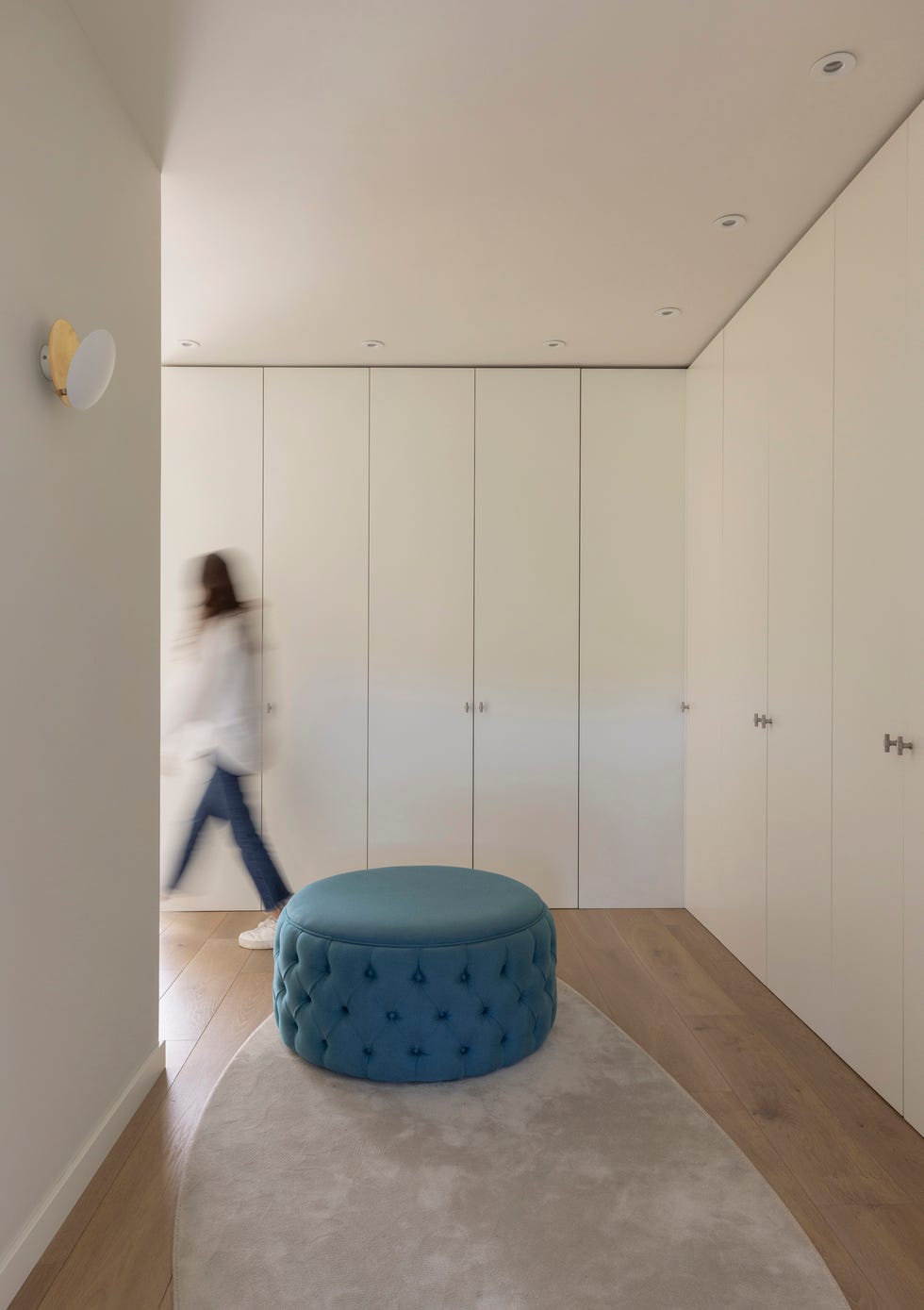 vestidor con armarios blancos y puf azul