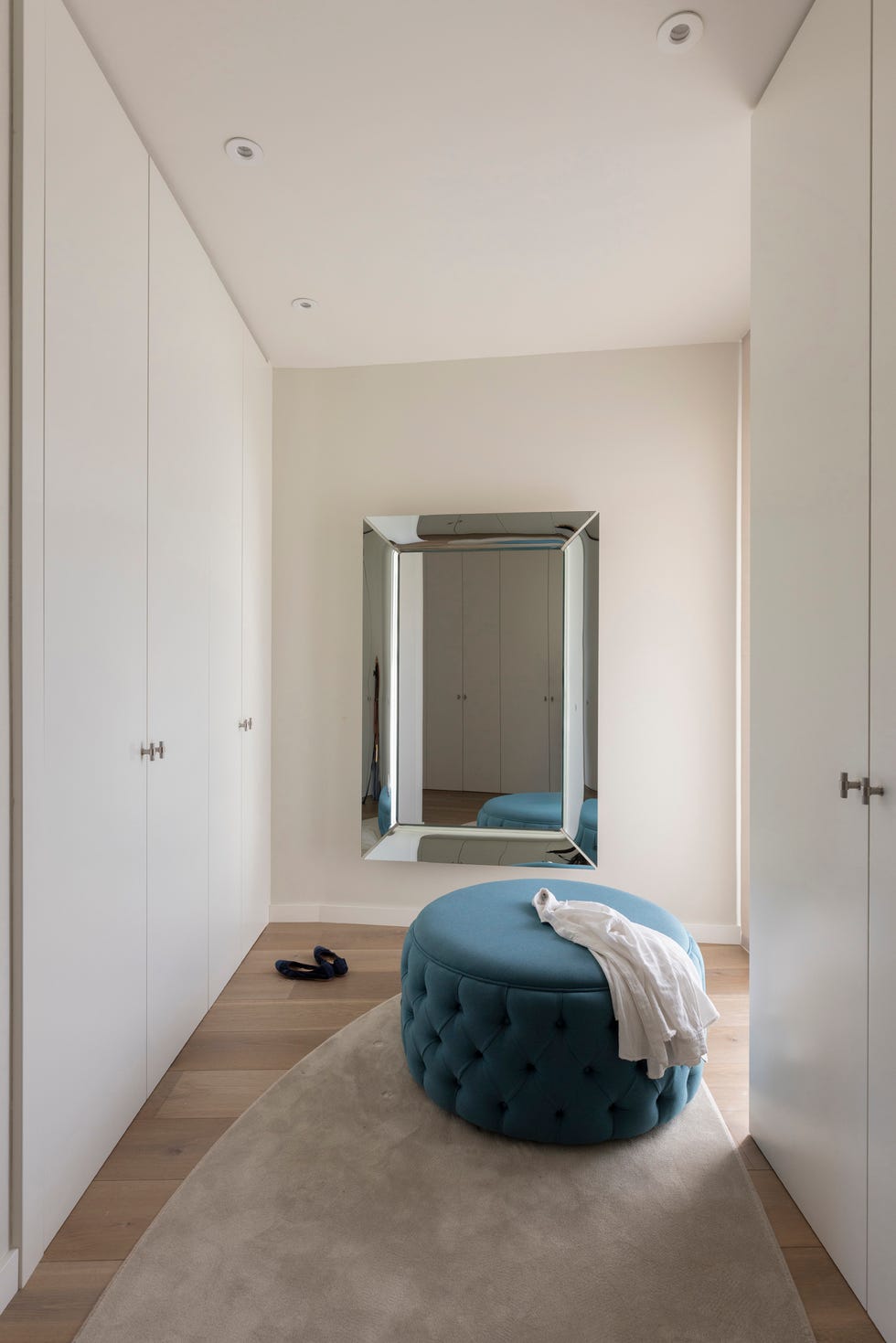vestidor con armarios blancos y puf azul
