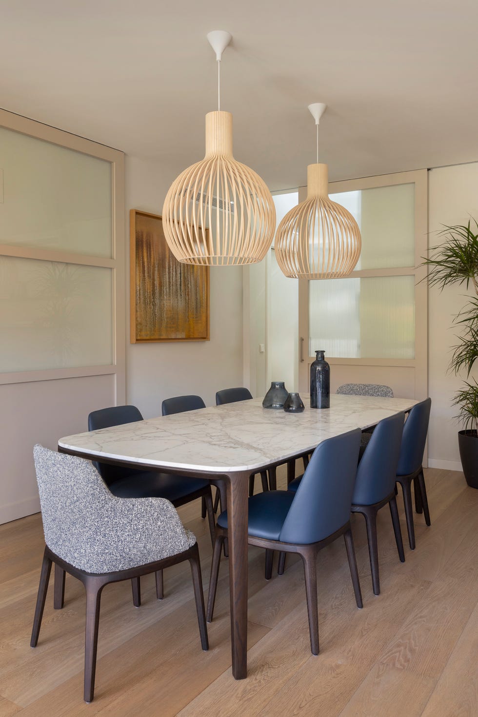 mesa de comedor con sobra de mármol y lámparas suspendidas