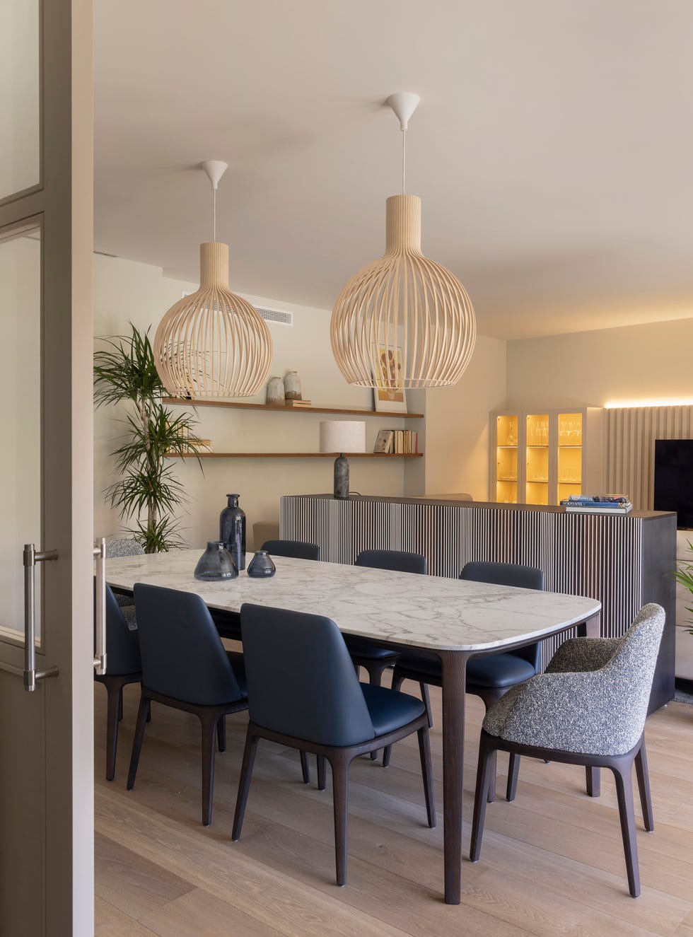 mesa de comedor con sobra de mármol y lámparas suspendidas