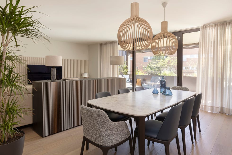 mesa de comedor con sobra de mármol y lámparas suspendidas