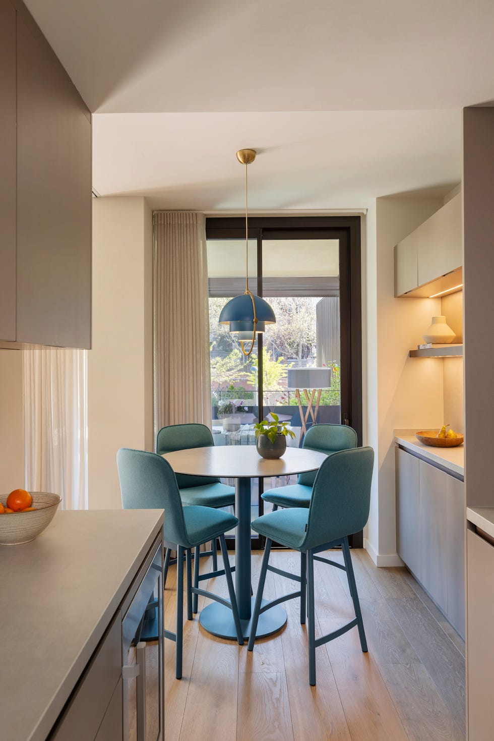 cocina con office compuesto por una mesa de sobra redondo y sillas azules