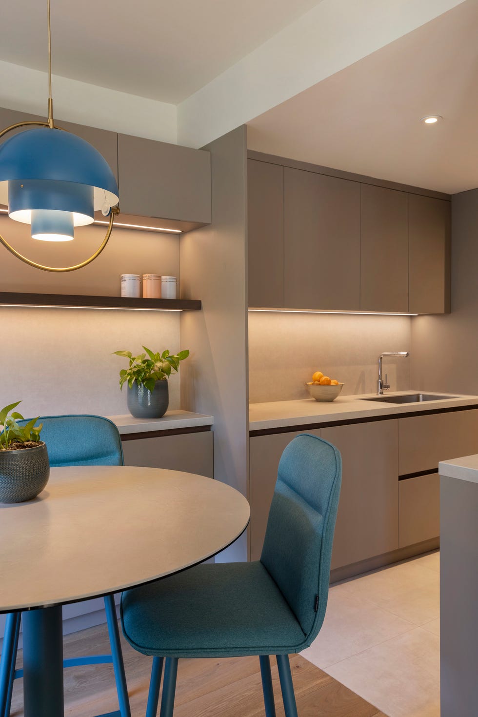 cocina con office compuesto por una mesa de sobra redondo y sillas azules