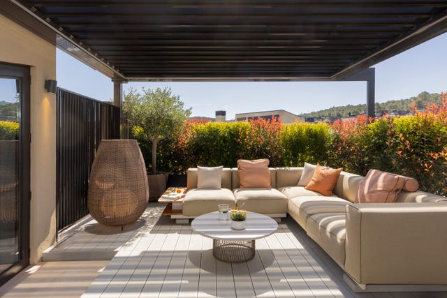 porche con pérgola y sofá rinconera