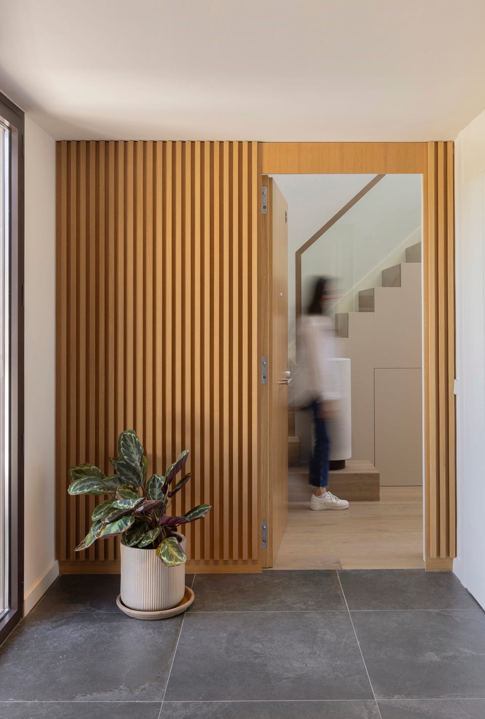 recibidor con revestimiento de listones de madera en la pared