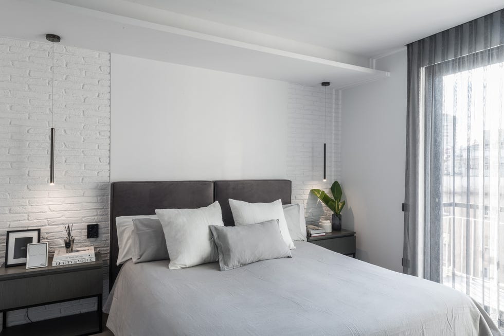 dormitorio moderno decorado en tonos grises con lámparas suspendidas