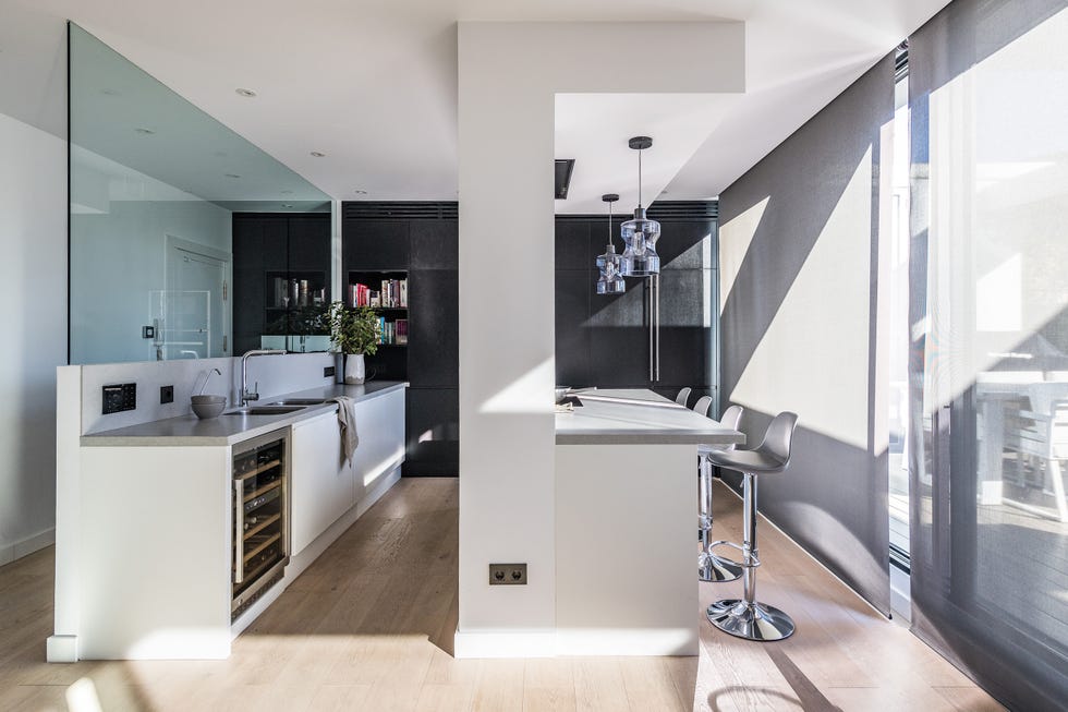 cocina abierta diseñada en blanco con barra de desayunos
