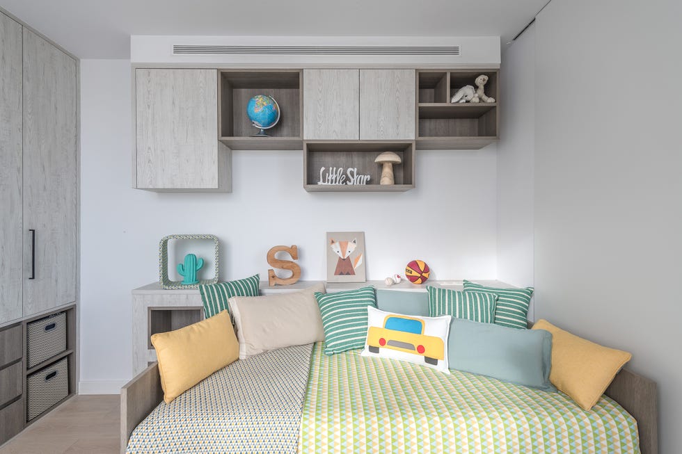 dormitorio infantil con mobiliario de madera y ropa de cama en tonos verdes