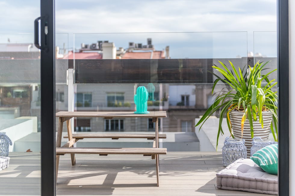 mesa con bancos de madera y cojines de suelo en la terraza