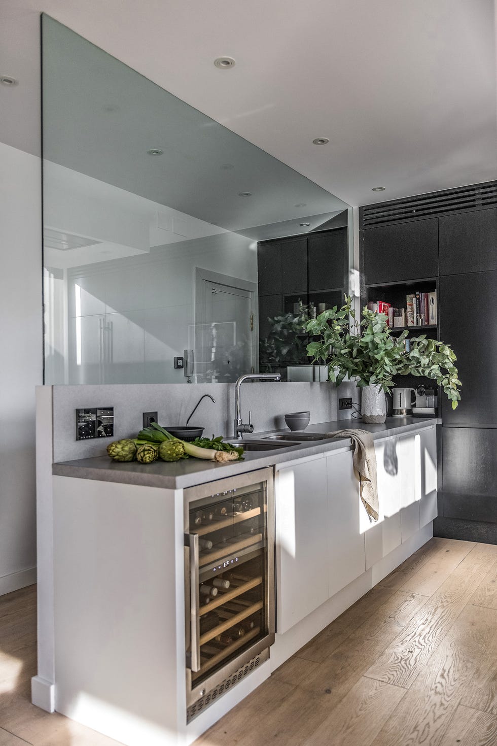 cocina abierta diseñada en blanco con murete acristalado