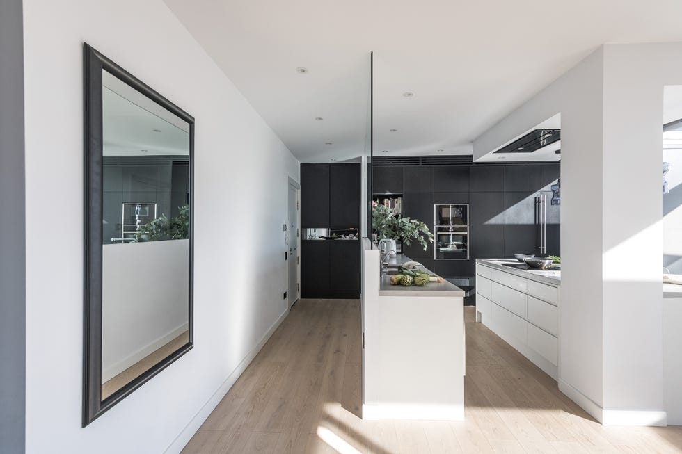 cocina abierta diseñada en blanco con murete acristalado