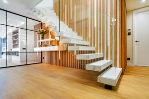 escalera con peldaños flotantes de mármol y barandilla de cristal