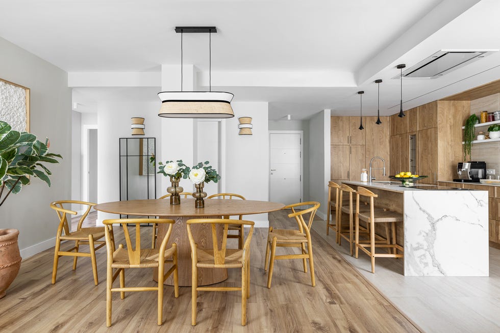 la cocina con isla del atico está abierta al salon y el comedor