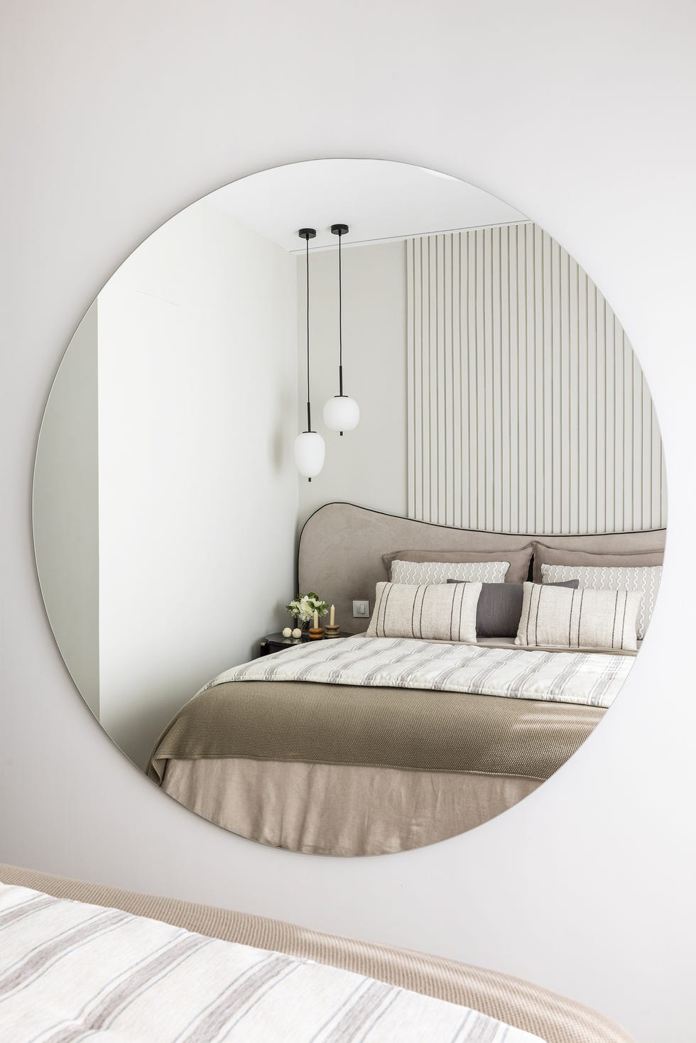 cama con cabecero curvado y lámparas colgantes