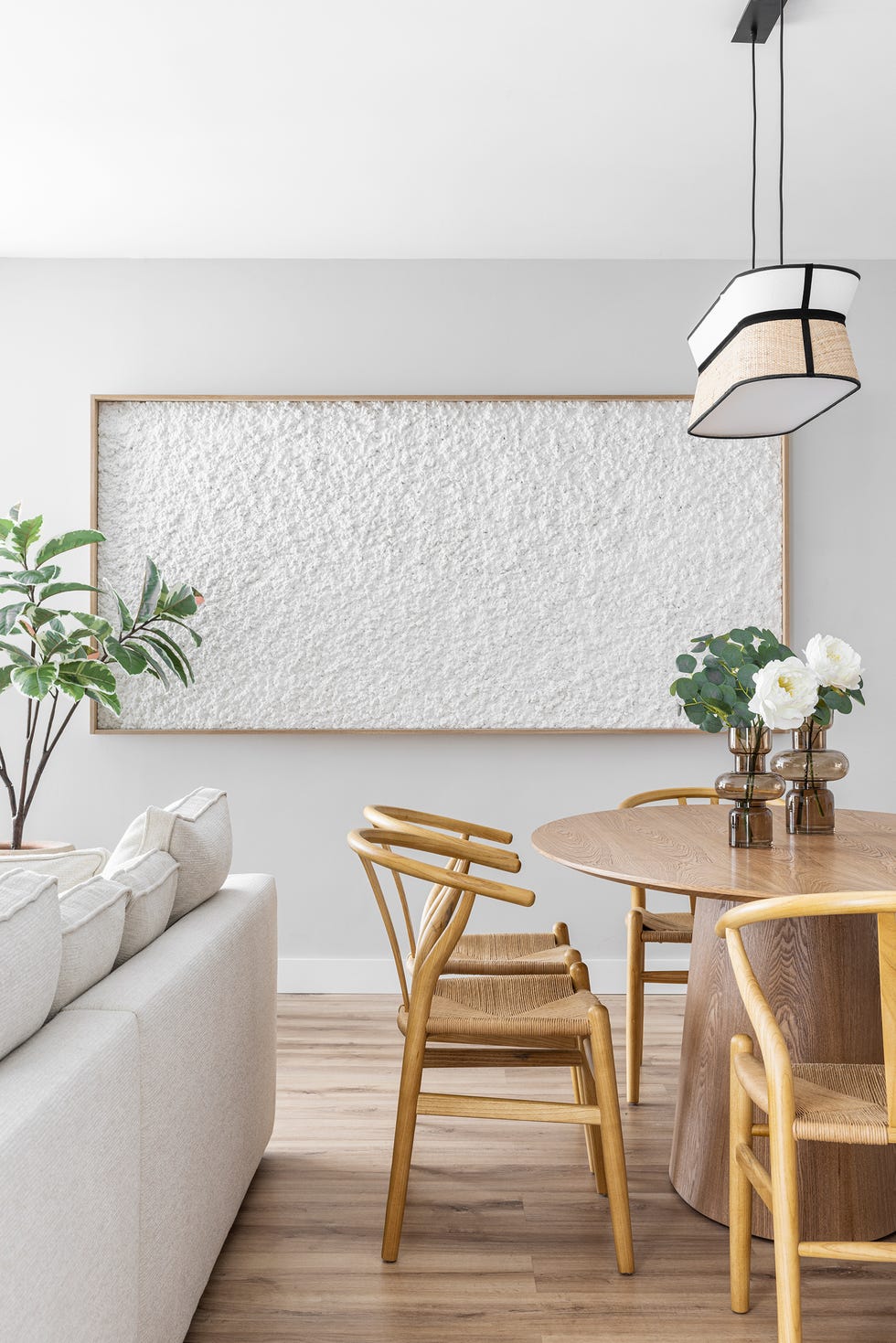 mesa de comedor ovalada con sillas de madera y lámpara suspendida
