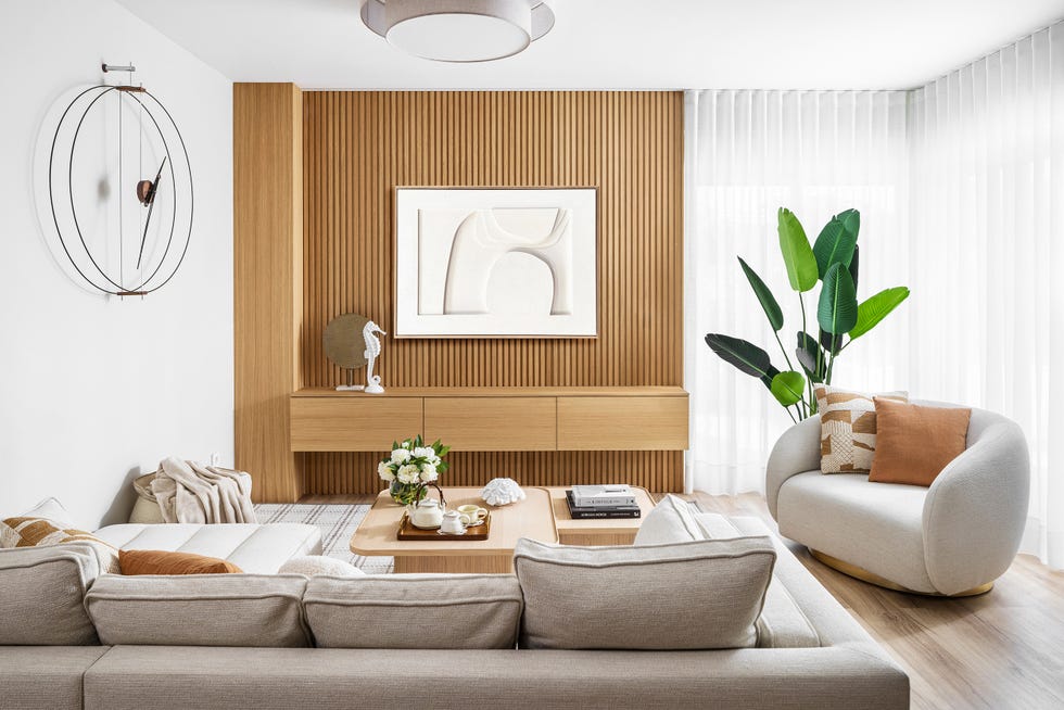 salón con frente de palillería de madera y sofá y butaca beige