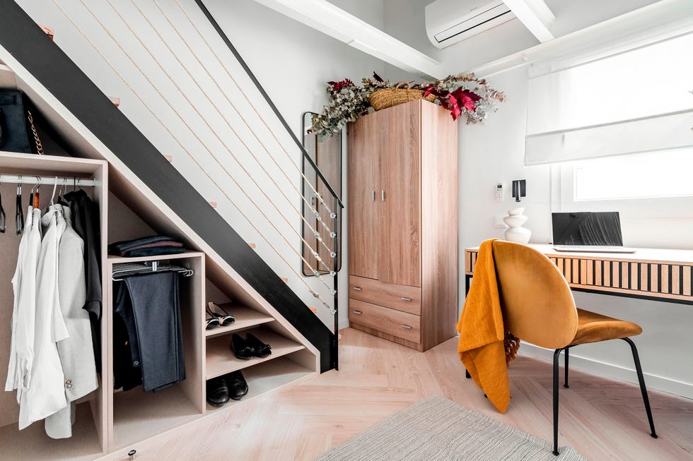 escalera con vestidor en el hueco y escritorio de madera