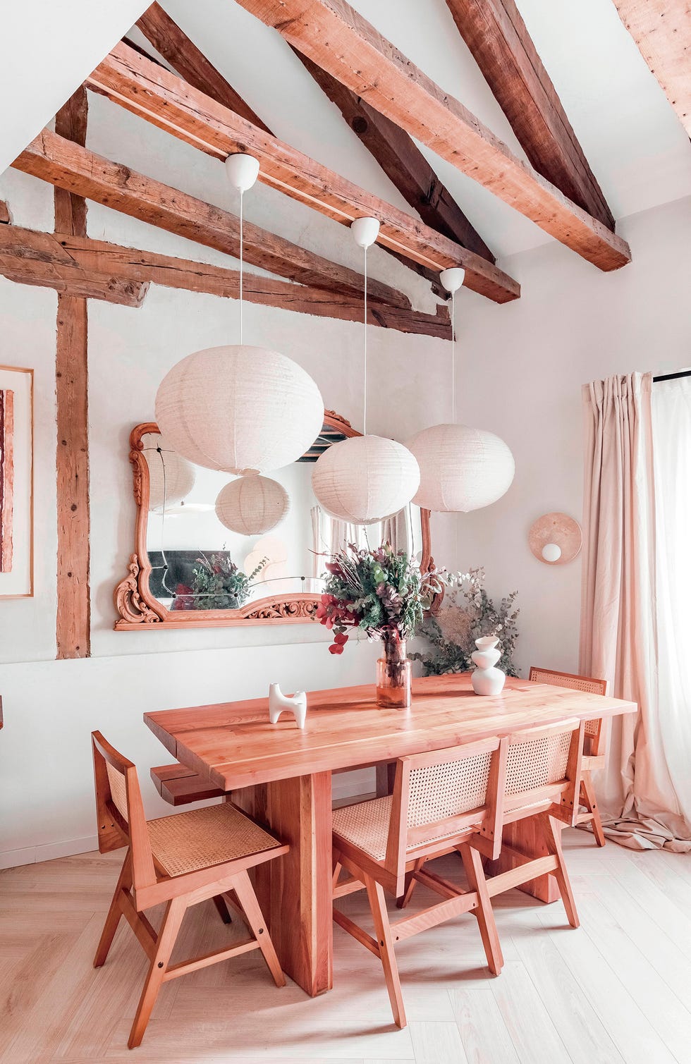 mesa de comedor y sillas de madera bajo techo con vigas vistas