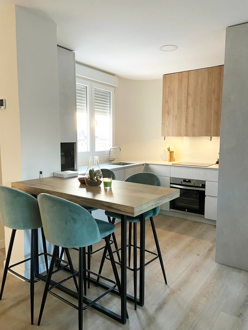 cocina con península de madera y taburetes de terciopelo turquesa